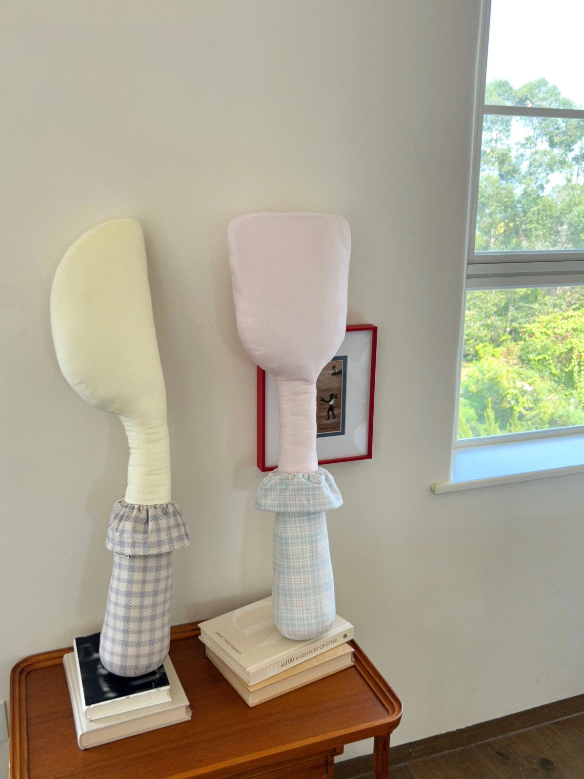 A yellow knife pillow and pink spatula pillow stand upright, with their ruffled handle collars clearly visible.