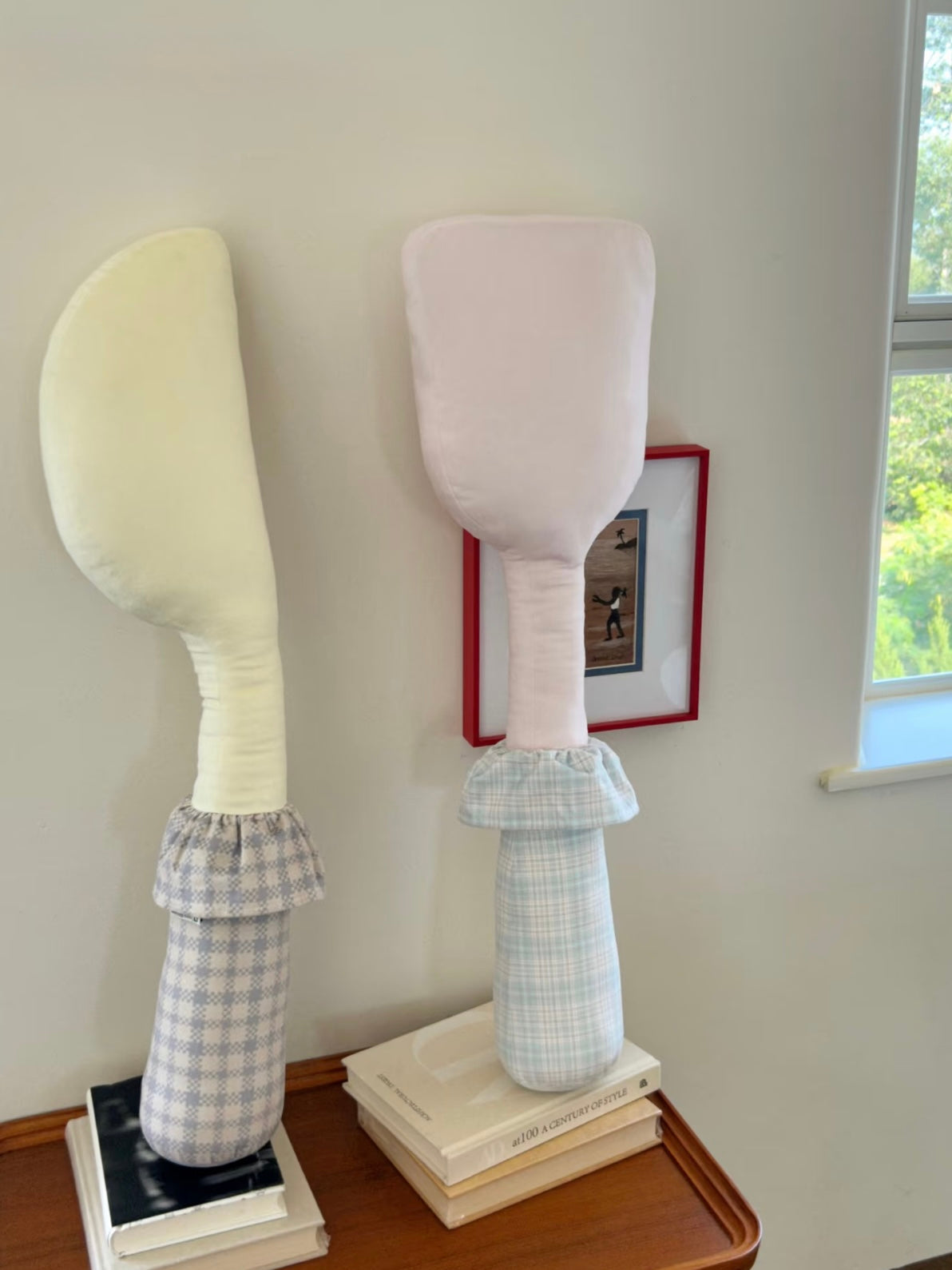 Yellow knife and pink spatula pillow designs stand side by side, with checked handles and gathered collars.
