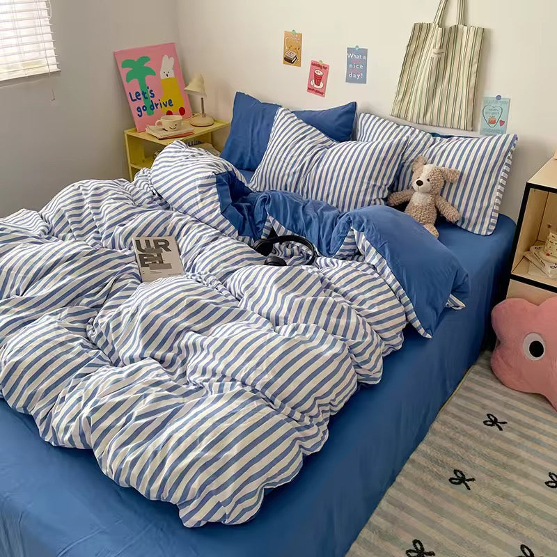 Cozy aesthetic blue striped bedding set styled with solid blue fitted sheet and plush accents.