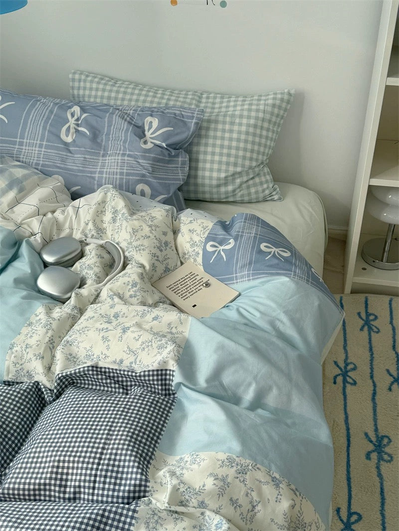 Bedding set with checkered and floral patterns on a bed in a room.