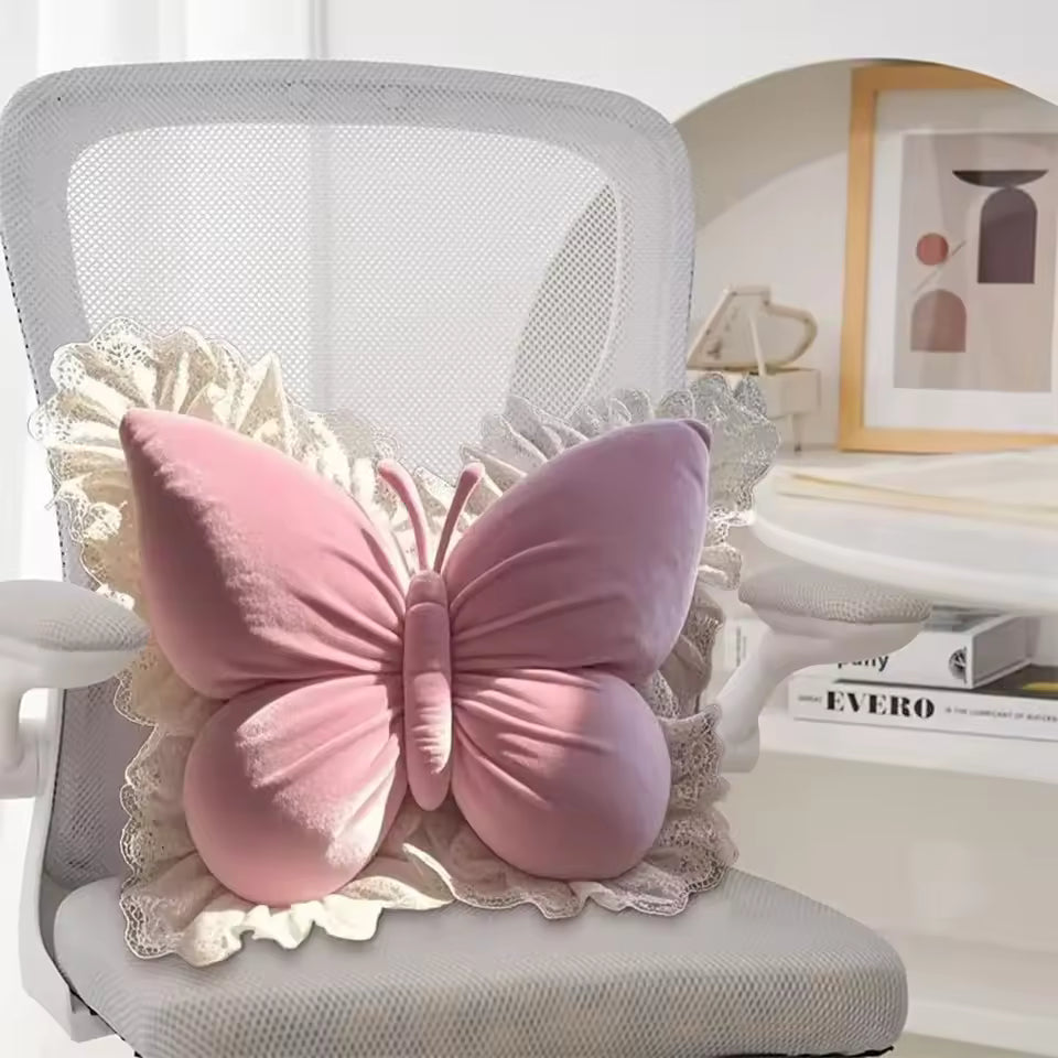 Pink butterfly-shaped pillow on a chair with a blurred background