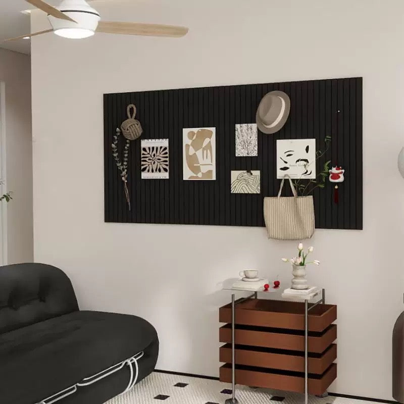 Wall with decorative items including a black textured panel, plants, and a bag.