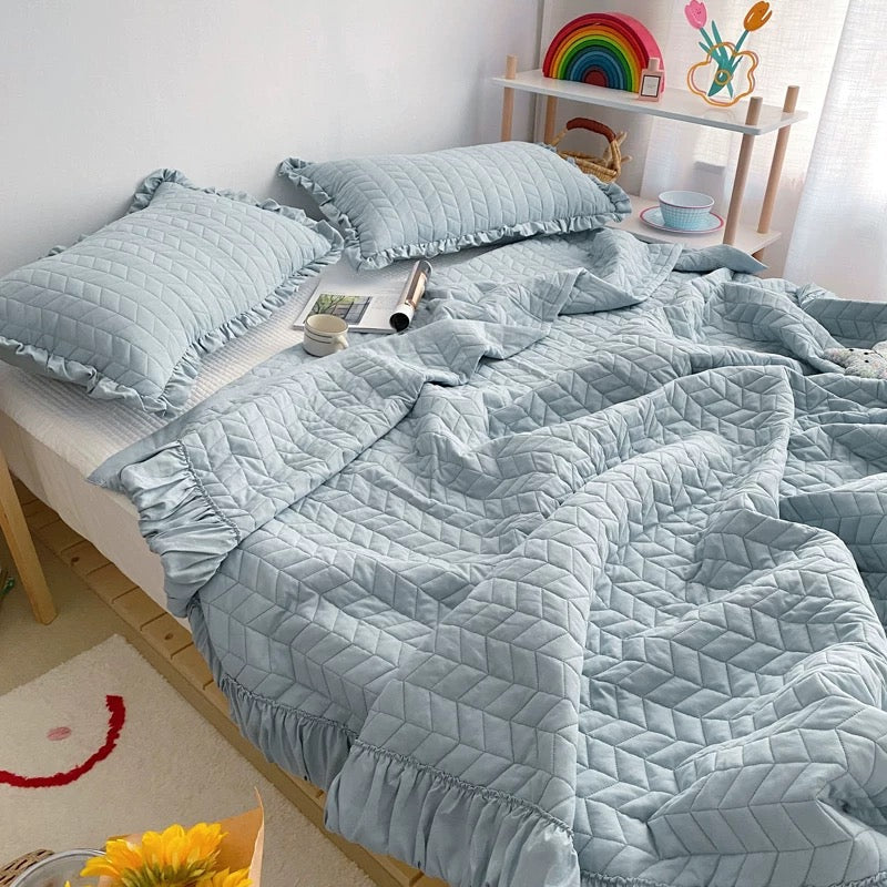 Lightweight polyester ruffle blanket with decorative quilted stitching
