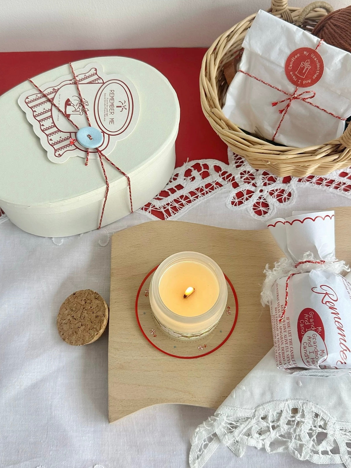 Lit wood wick scented candle styled beside the Christmas gift box