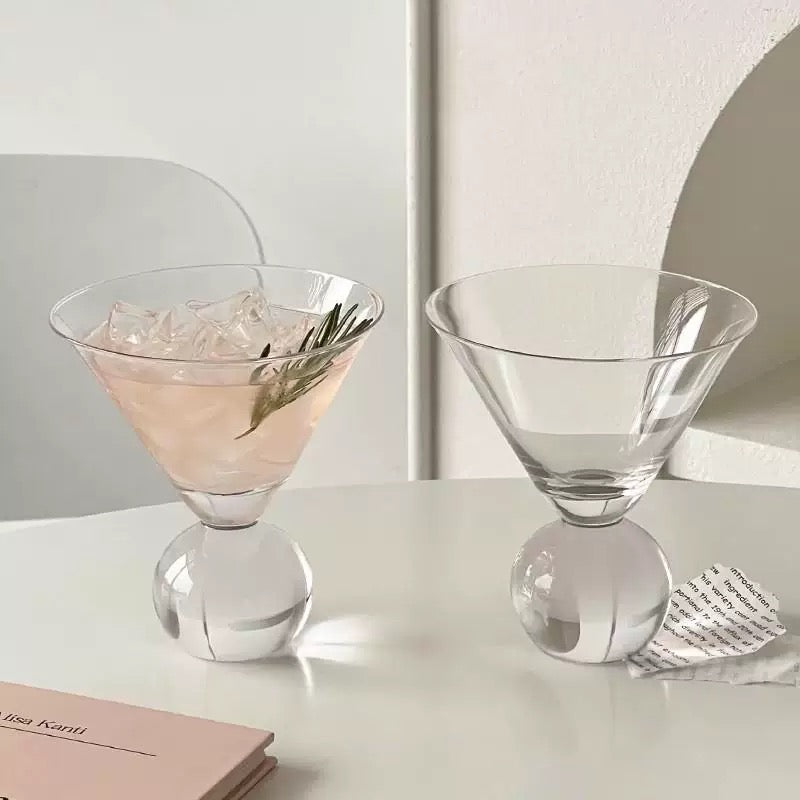 Two cocktail glasses on a light surface with a minimal background