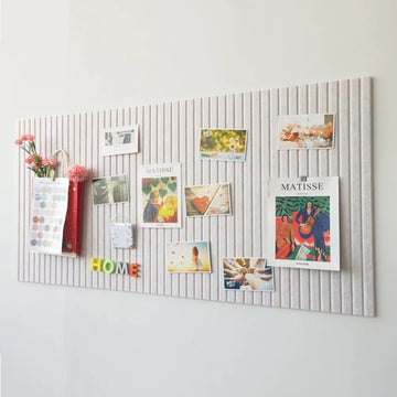 Decorative wall panel with pinned photos and notes on a light gray background