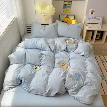 Coquette bedroom setup with heart bedding and soft lighting.