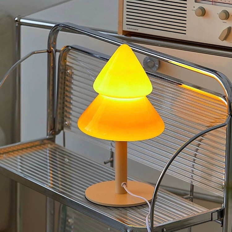 Yellow cone-shaped lamp on a metal surface with a vintage radio in the background