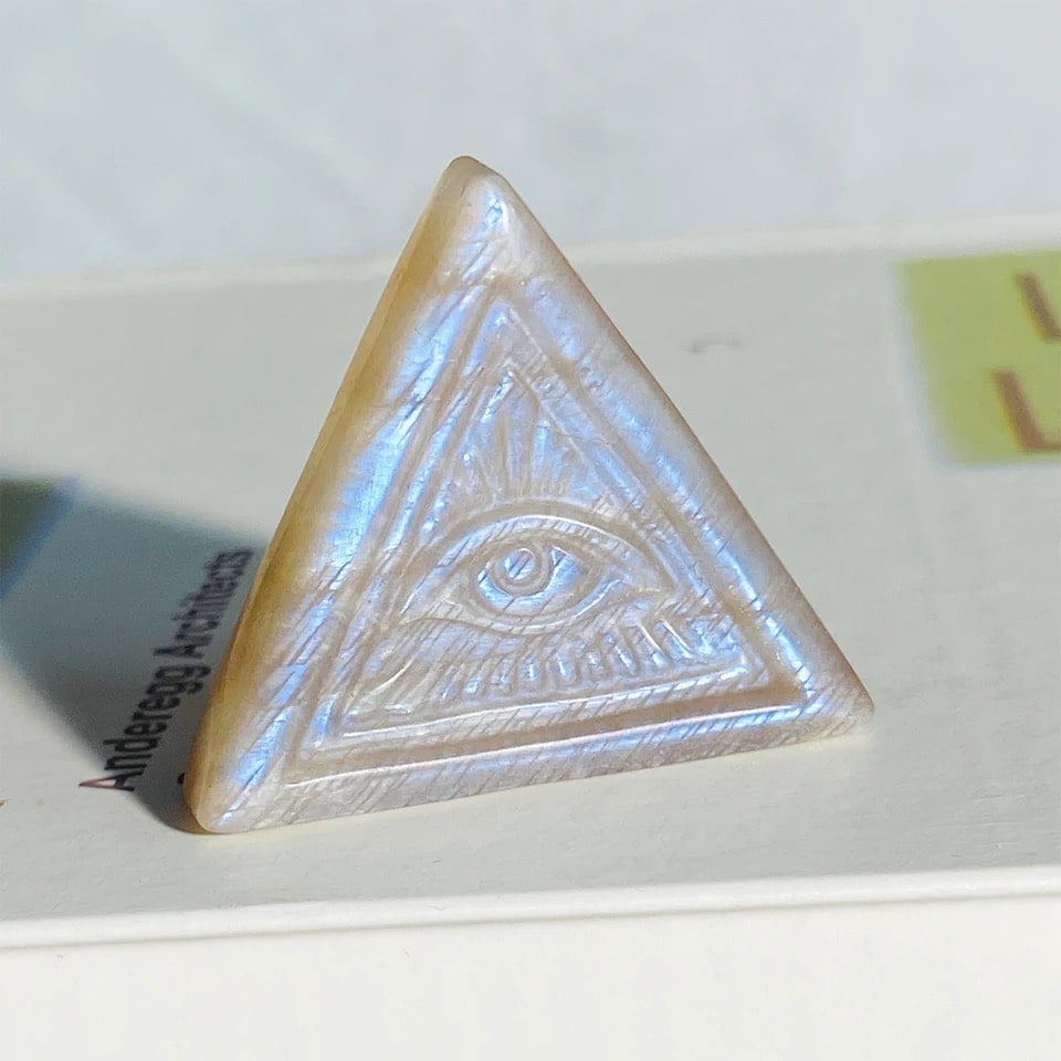 White moonstone crystal with evil eye carving, natural moonlight stone for home, office, and meditation. Features blue flash for crystal healing.