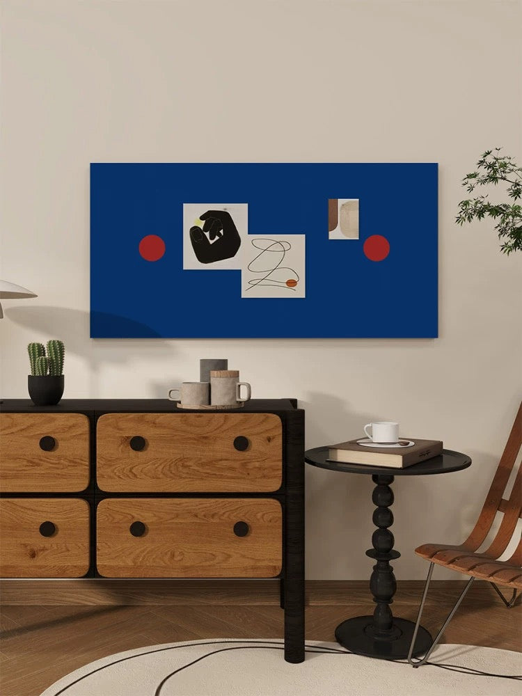Navy blue felt bulletin board with red circles and pinned prints above a wooden cabinet.