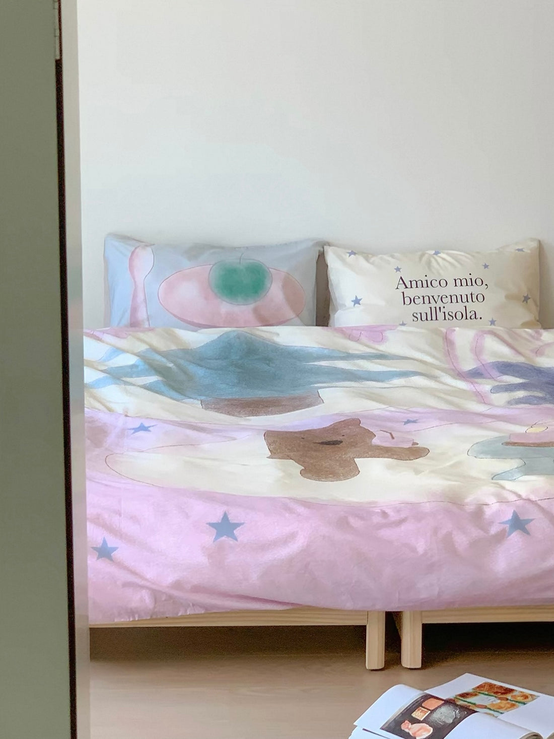 Pink teddy bear bedding shown from the front with pastel tableware shapes and stars.