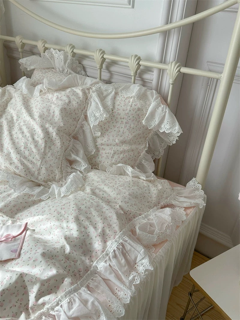 White lace dress on a white bed with a white headboard.