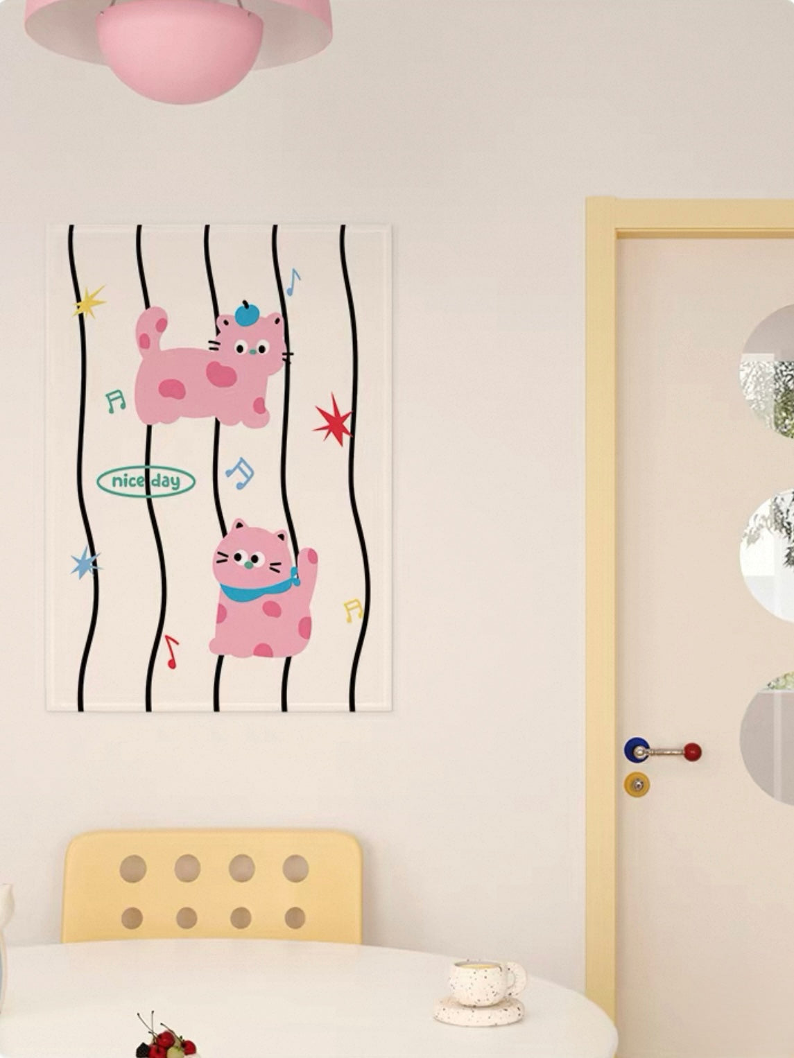 A pink cat tapestry shows two cartoon cats among black wavy stripes, small colored stars and musical notes.