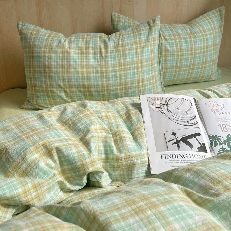 Plaid bedding set with a magazine on a bed