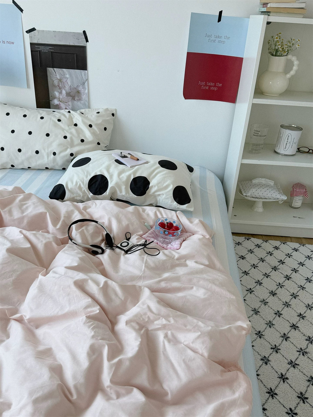 Small and large black dot pillowcases on white are paired with a plain pink duvet cover.