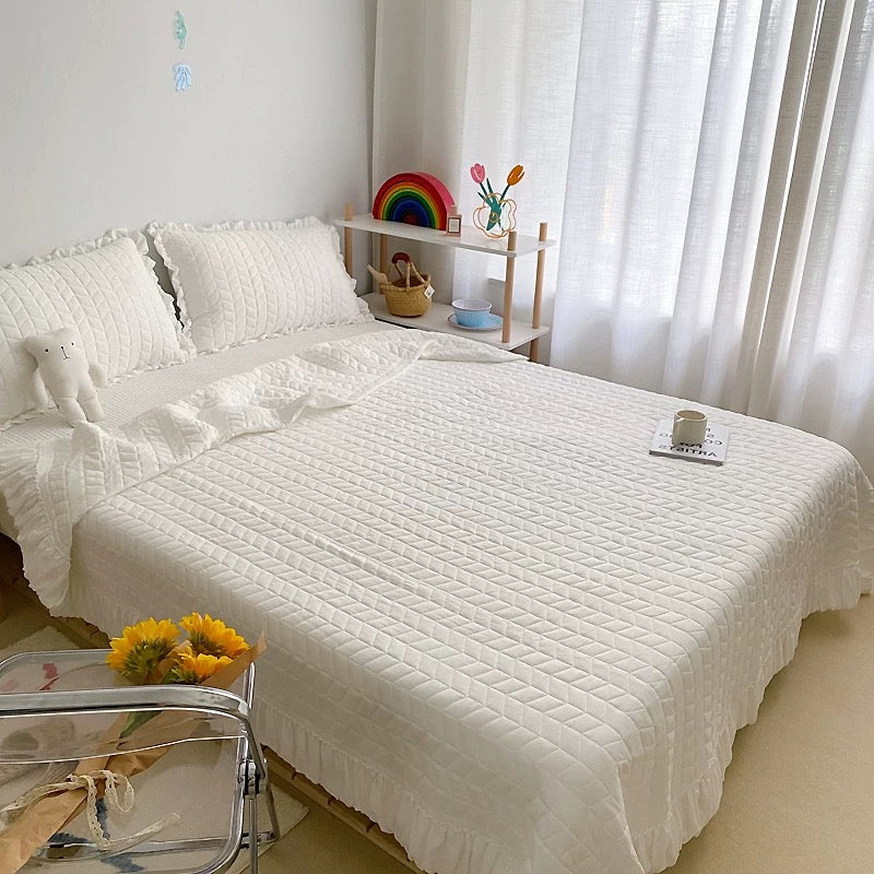Polyester quilted blanket finished with delicate ruffle trim
