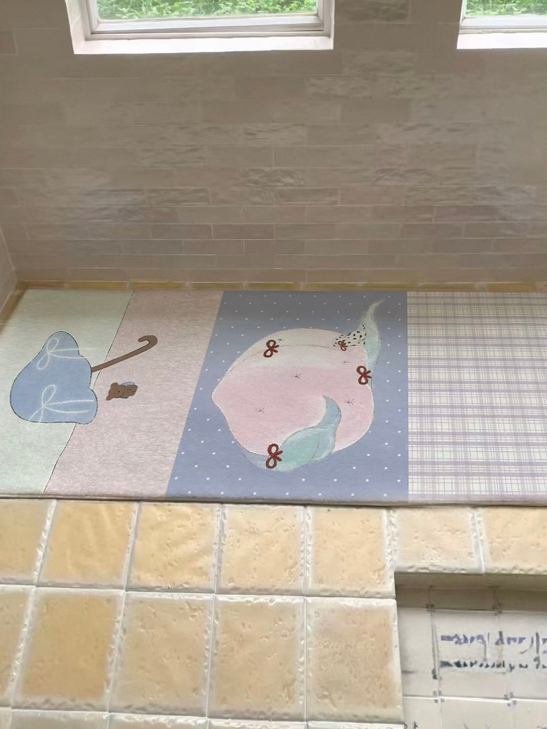 A purple peach rug lies horizontally below a window, with its pink peach and checked panels visible.