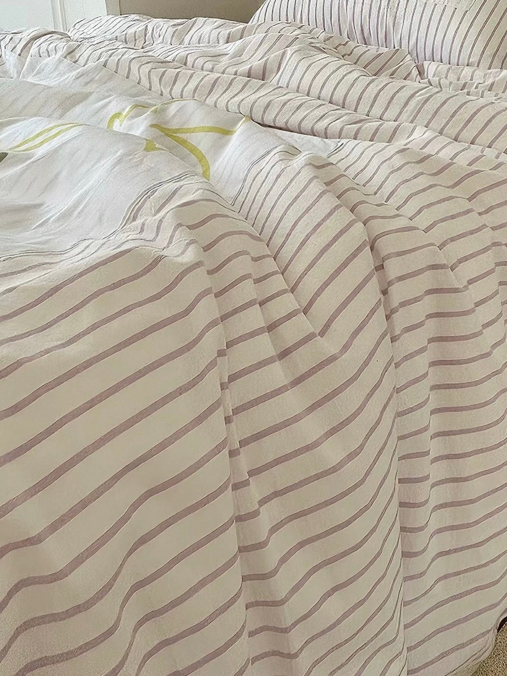 Close-up of narrow purple stripes and soft folds across the washed cotton duvet cover.