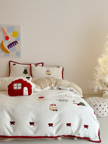 Red bow Christmas bedding set styled on a white bed with embroidered holiday motifs