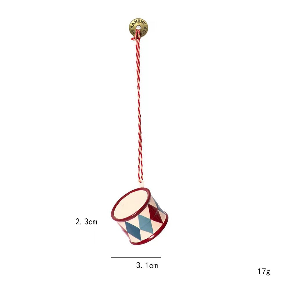 A red, white and blue drum ornament has diamond panels, a white drumhead and a twisted hanging cord.