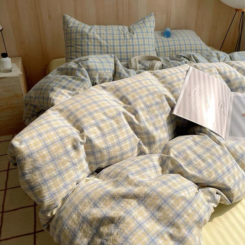 Bed with checkered bedding and pillows in a bedroom setting.