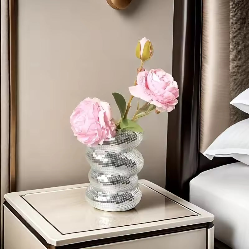 Decorative vase with pink flowers on a nightstand