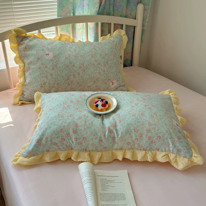Textured seersucker floral fabric with pink roses and yellow ruffle edge shown up close
