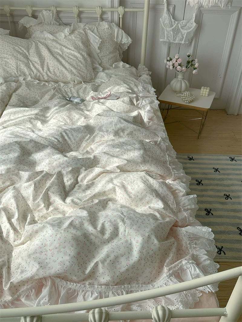Bed with ruffled bedding and pillows in a softly lit room.