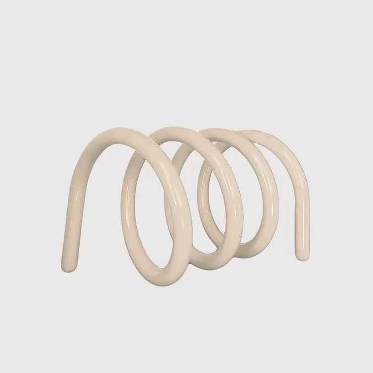 Minimalist metal book holder standing on bedside table, keeping current reads neat and visually pleasing.