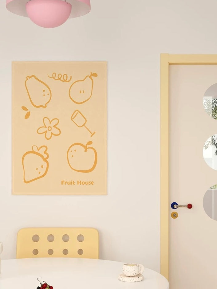A yellow short plush tapestry hangs above a yellow chair, with large fruit outlines filling the vertical panel.