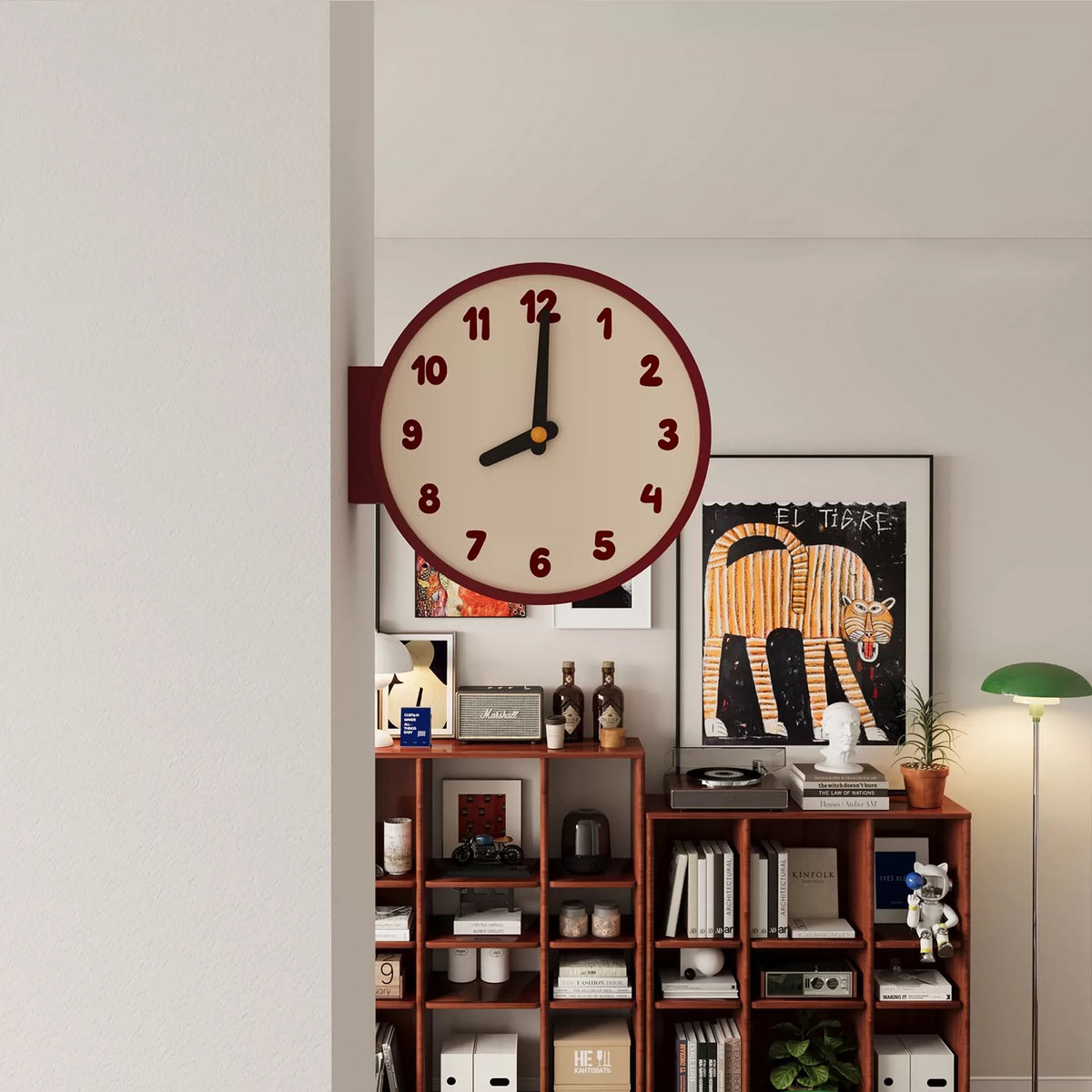 Wall clock on a shelf with decorative items against a light gray wall