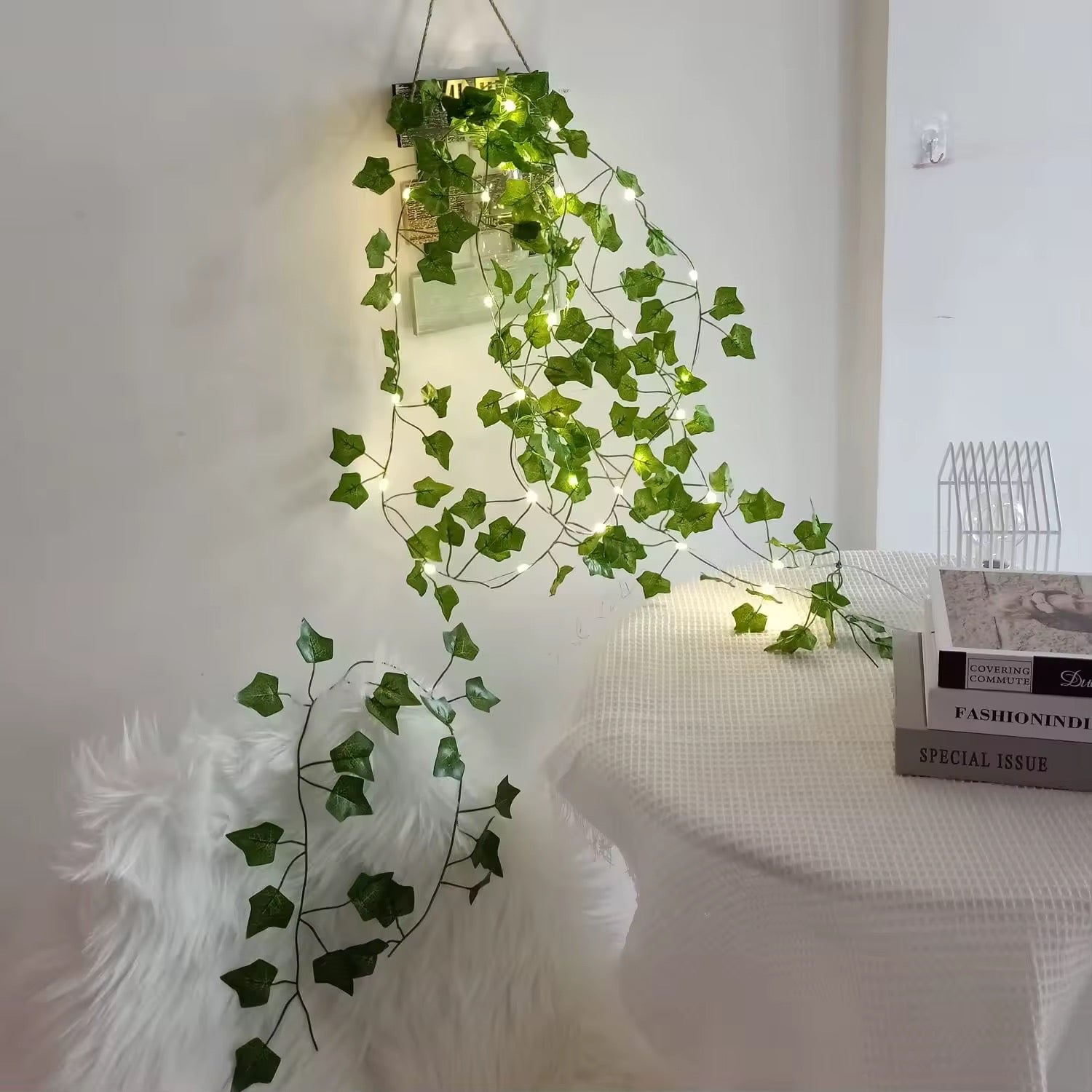 Battery-powered LED ivy string light hung across a white wall in a cottagecore-themed bedroom.