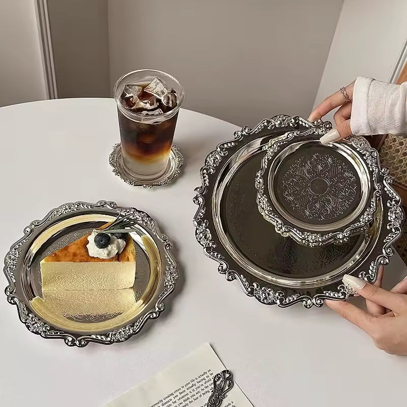 Silver platters with a dessert and a drink on a table