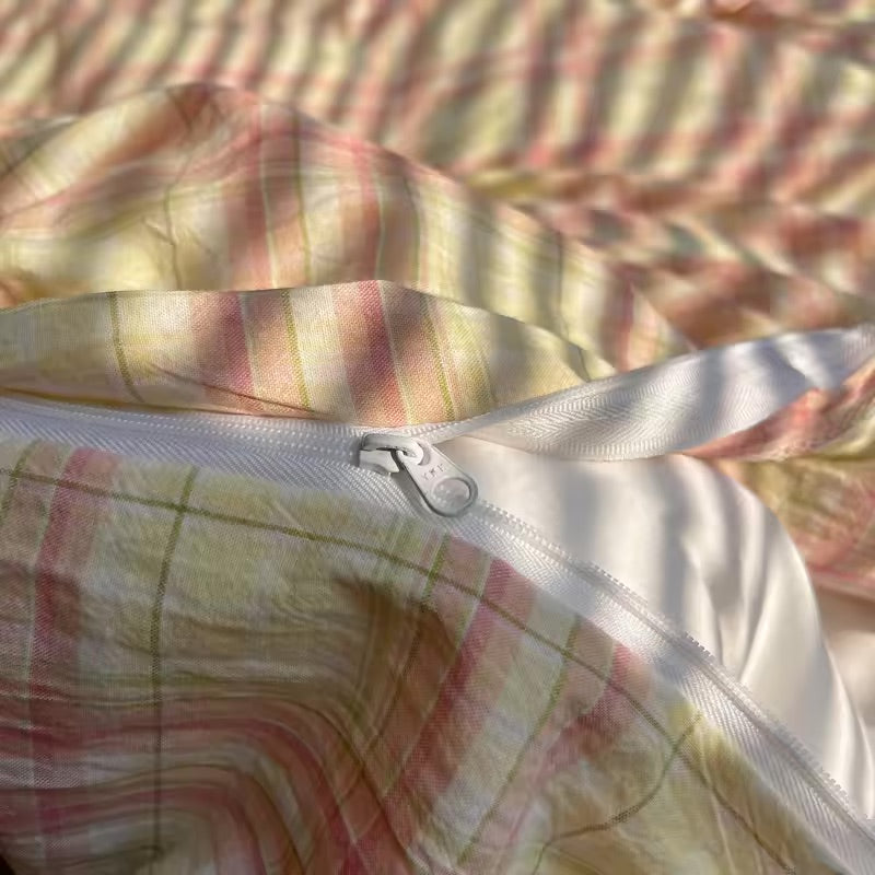 Close-up of a plaid fabric with a zipper, on a checkered background.