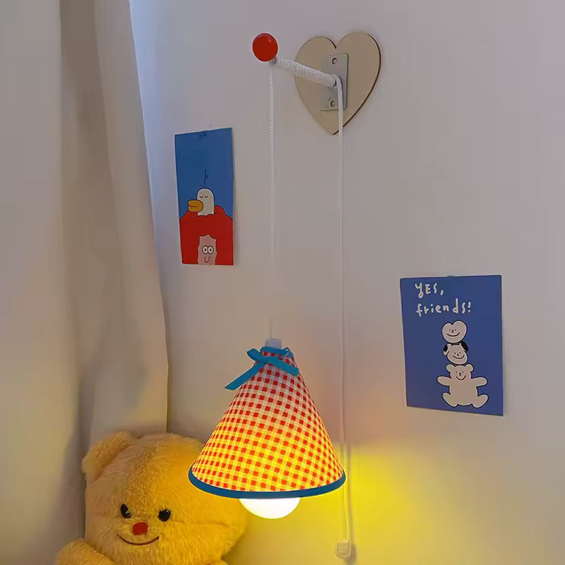 Children's room with a checkered lamp, teddy bear, and wall decorations.