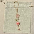 Decorative string with a pink star and floral elements on a textured beige background