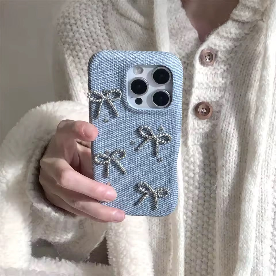 Person holding a blue phone case with bow designs