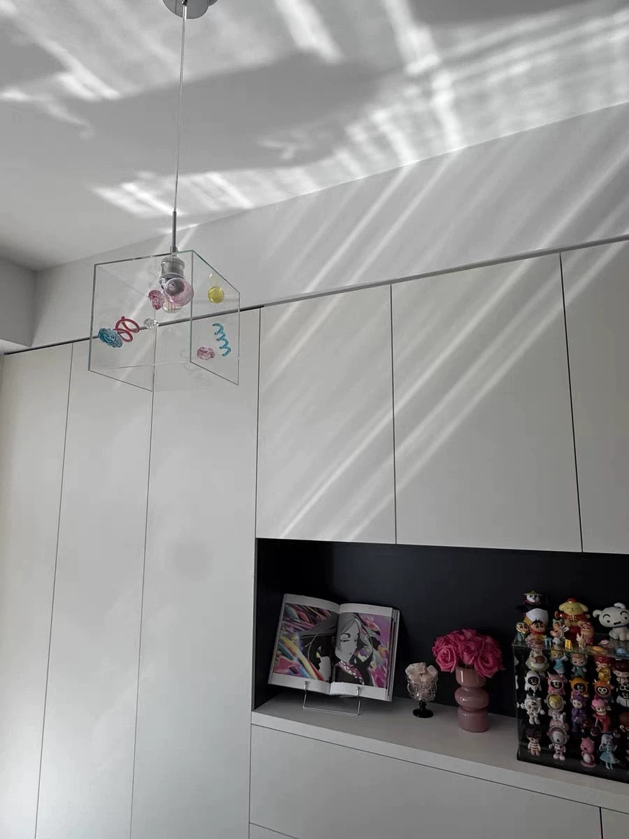 White wall with a shelf displaying various items including figurines and a vase.