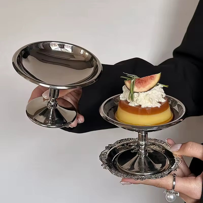 Delicate dessert on a silver stand held by hands against a neutral background