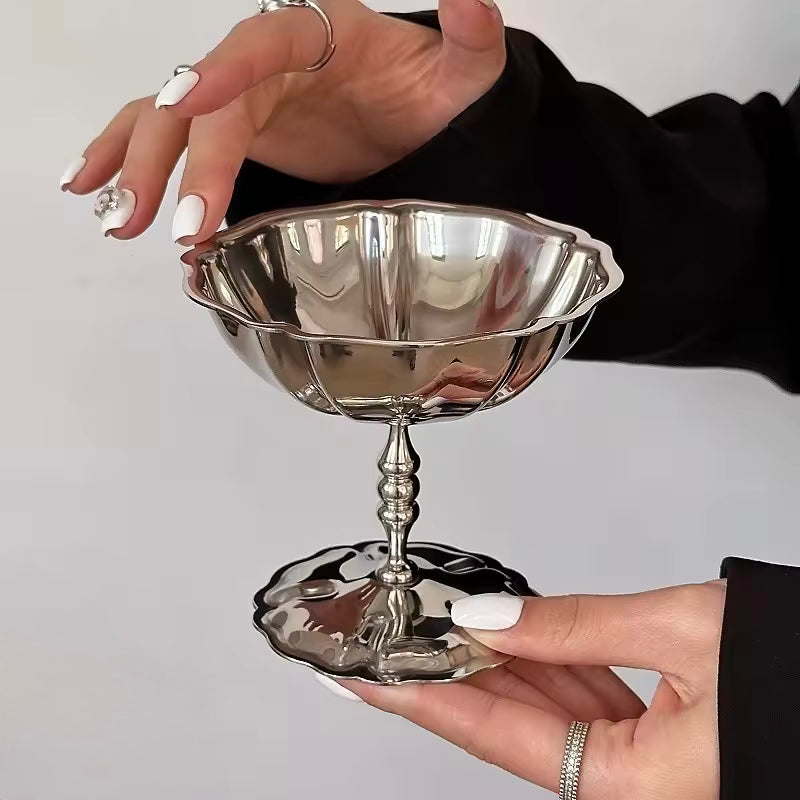 Silver decorative bowl held by a person against a neutral background