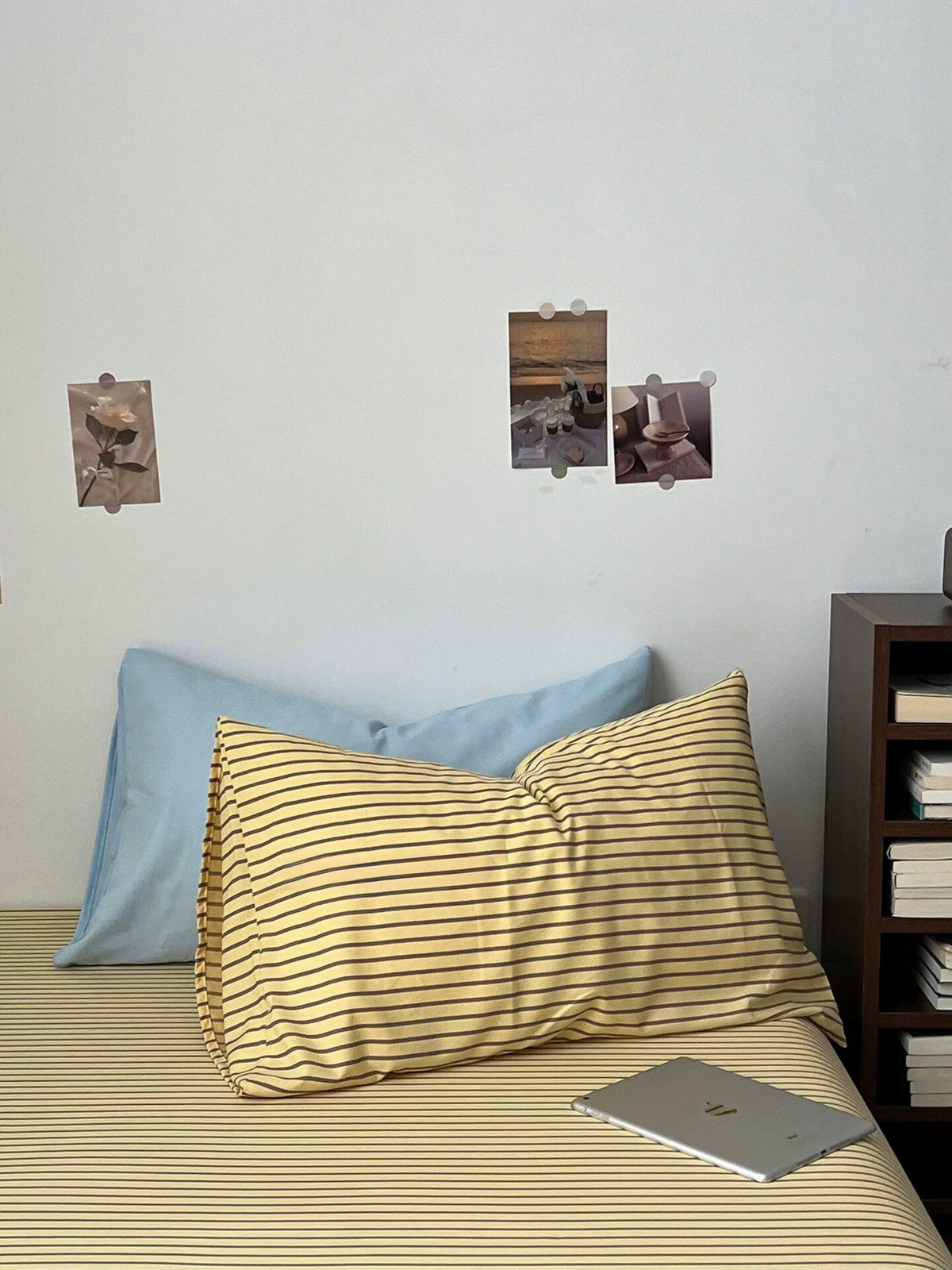 Fine striped sheet with pale blue and striped pillowcases on the bed