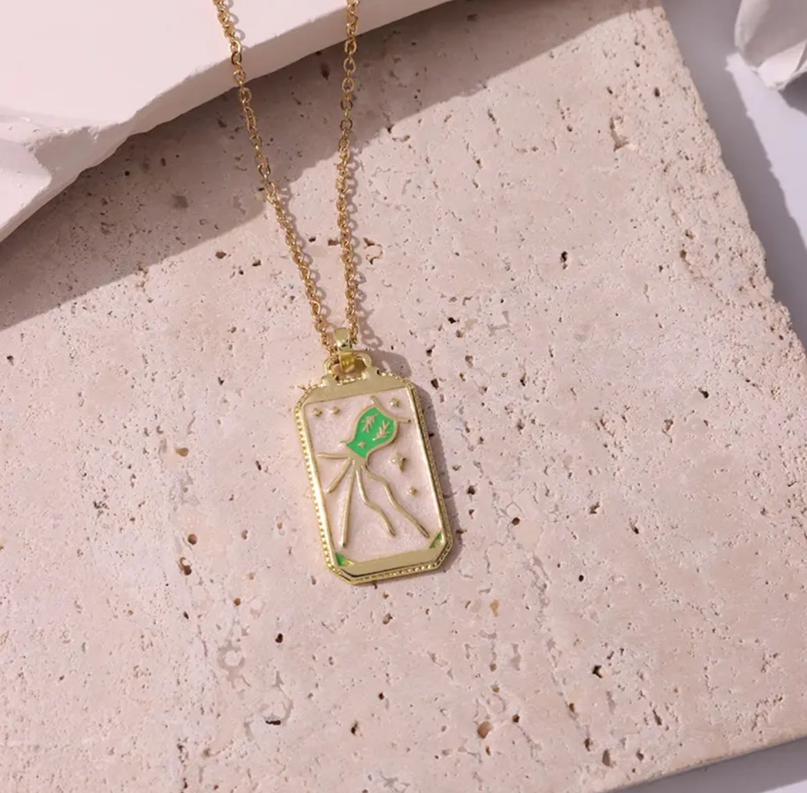Intricately designed pink tarot card pendant necklace, a symbol of mystery and intrigue.
