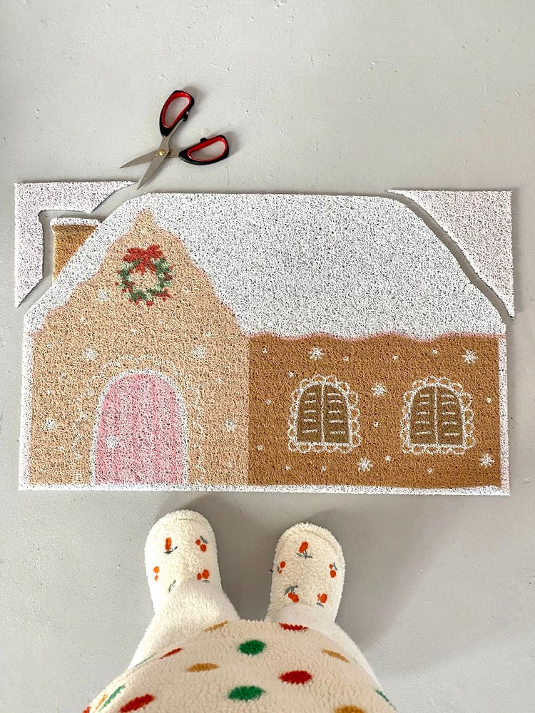 Gingerbread doormat with scissors showing the trim-to-shape house outline