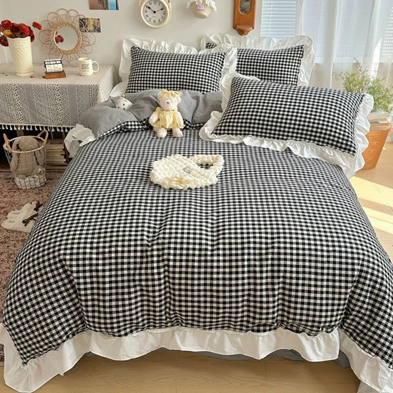 Bed with black and white checkered bedding in a bedroom setting.