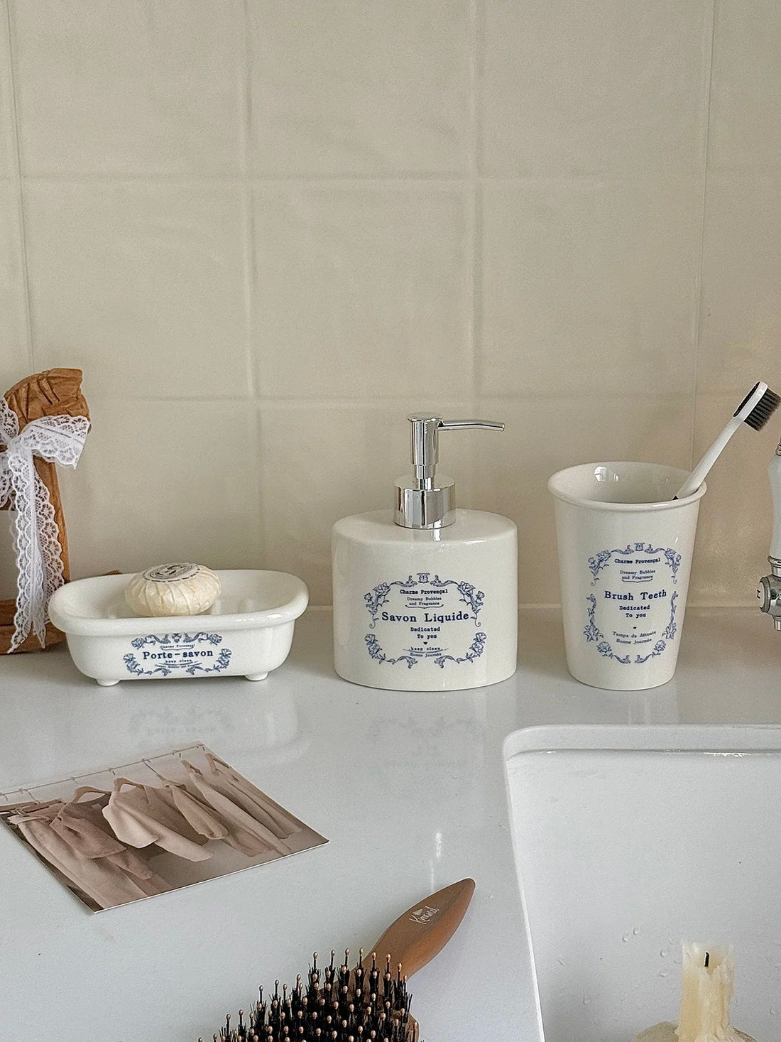 A Cottagecore soap dispenser display shows blue floral lettering and blue and red swan designs on a shelf.