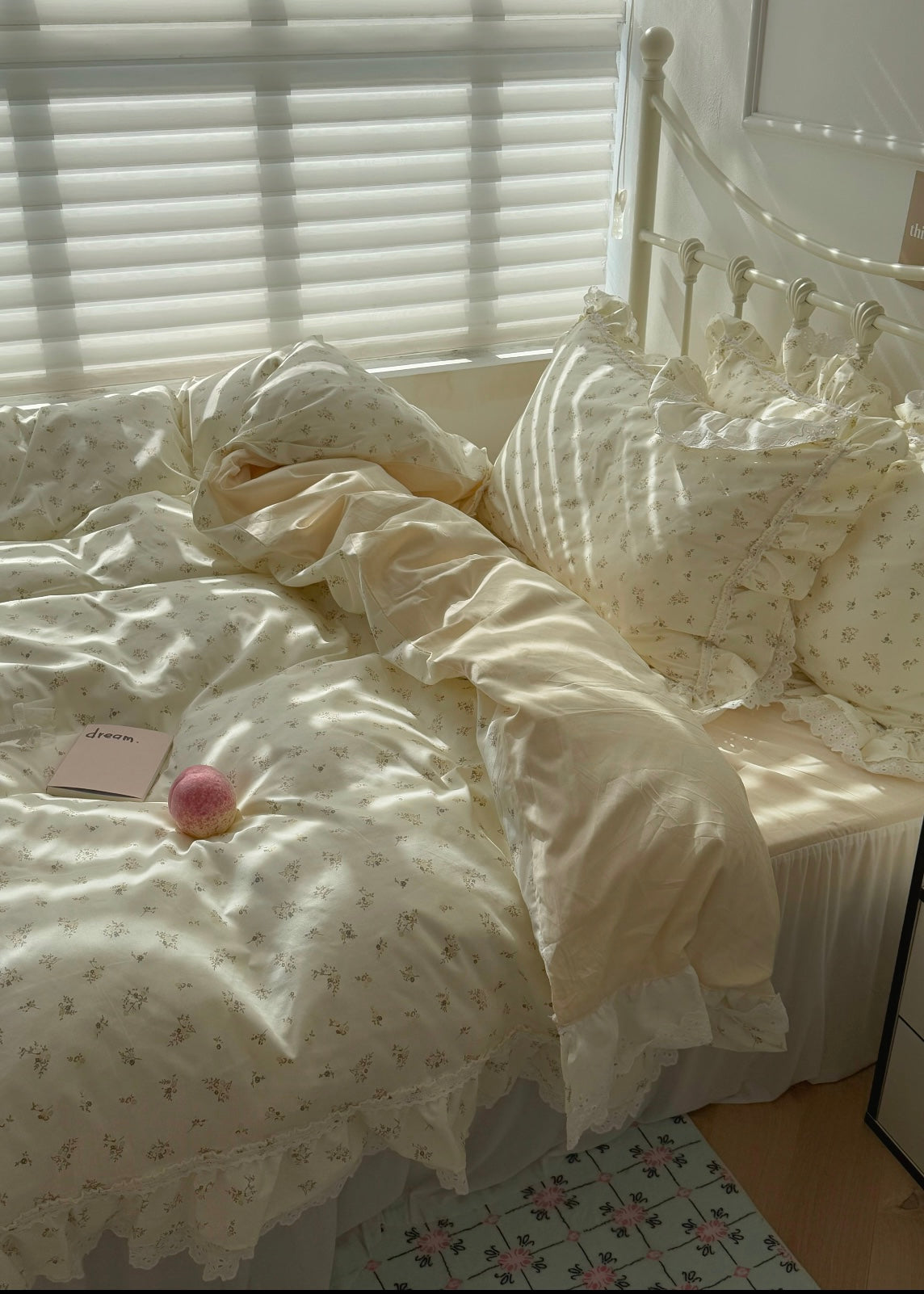 Bed with white bedding and a pink ball on a tiled floor.