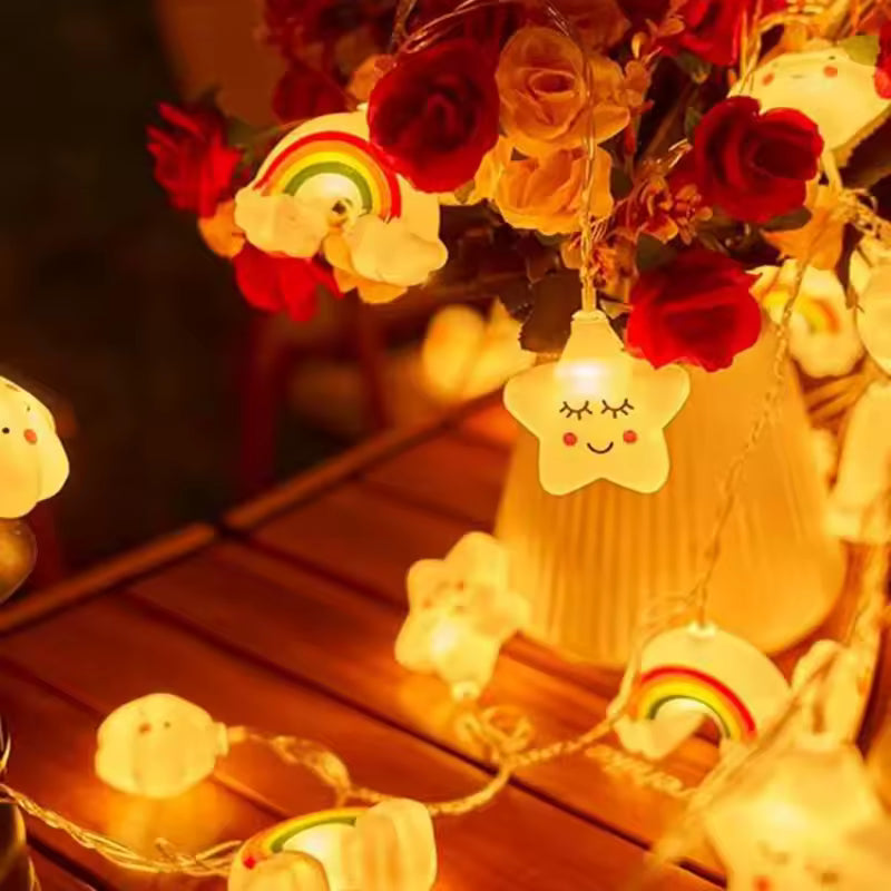 String lights with cartoon character designs on a wooden surface with flowers in the background