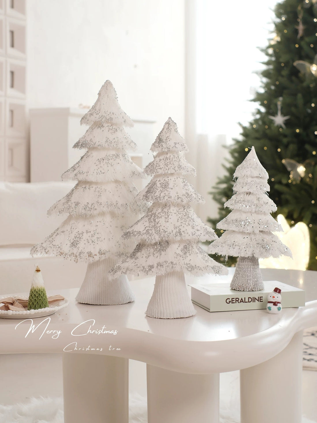 A sequin Christmas tree with white fringed tiers and silver accents is held upright to show its full shape.